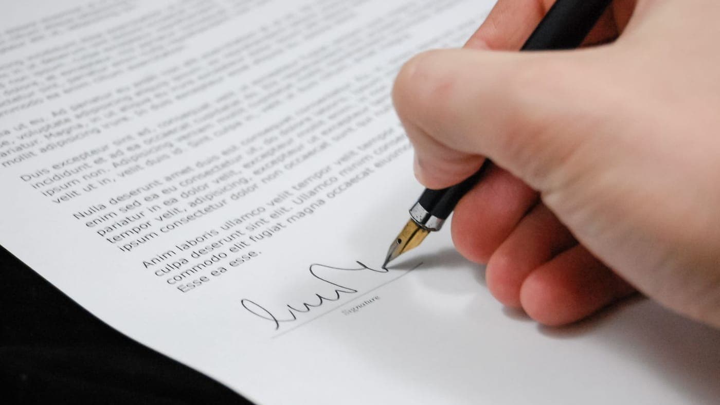 Pessoa assinando um documento contratual